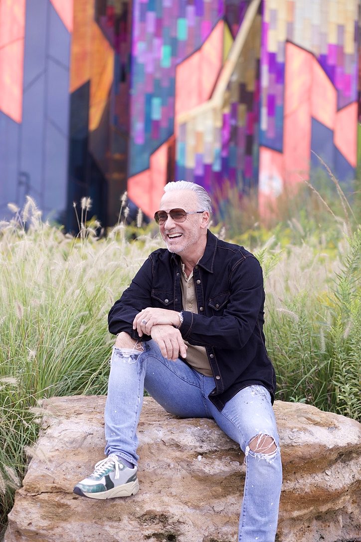 Glenn seated in a black denim overshirt